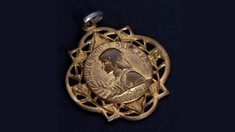 Pendentif Sainte Jeanne d’Arc, priez pour nous XXe siècle / Métal doré / 2012.1.70